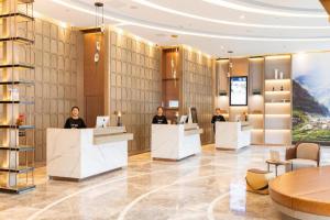 a lobby with people sitting at reception desks at Atour Hotel Huainan Railway Station Commercial and Cultural Square in Huainan