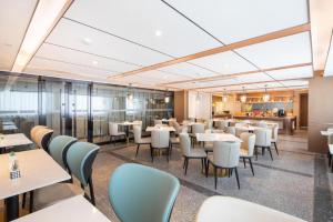 a restaurant with tables and chairs and a cafeteria at Atour Hotel Huainan Railway Station Commercial and Cultural Square in Huainan