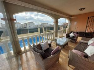 a large room with a balcony with chairs and a table at Villa Christophe in Alicante