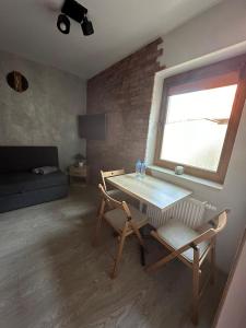 a living room with a table and chairs and a window at Pokoje przy Kawiarence in Rewa