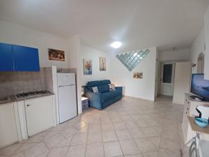 uma cozinha e sala de estar com um sofá azul em CASA MONELLA mono locale vista mare em Marinella