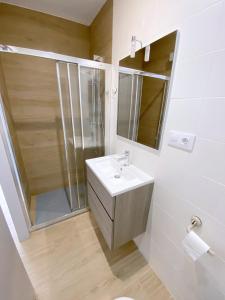 een badkamer met een wastafel, een douche en een spiegel bij Verones 1b in Roses