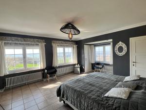una camera da letto con un letto grande e finestre di Oneux Village a Theux