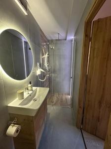 a bathroom with a sink and a shower with a mirror at Pokoje przy Kawiarence in Rewa