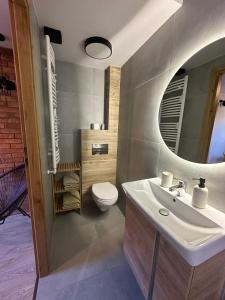 een badkamer met een witte wastafel en een toilet bij Pokoje przy Kawiarence in Rewa