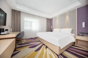 een hotelkamer met een groot bed en een bureau bij Starway Hotel Nanjing Jiaoyuan Metro Station in Jiexi