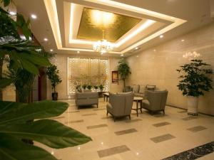 a lobby with chairs and a table and a chandelier at Starway Hotel Changji Qitai Bus Station in Xibeiwan