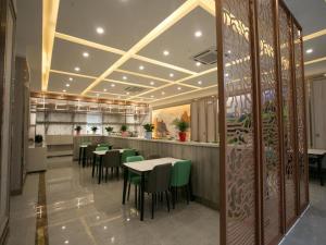una sala da pranzo con tavoli e sedie verdi di Starway Hotel Changji Qitai Bus Station a Xibeiwan