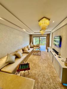 a large living room with a couch and a tv at Golf City Prestigia - Exclusive Apartment in Marrakesh