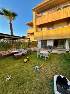 a house with a yard with a lawnituresitures at Golf City Prestigia - Exclusive Apartment in Marrakesh