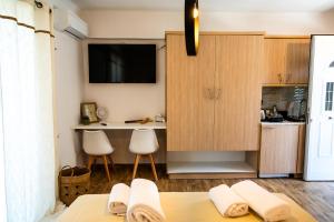 a kitchen with wooden cabinets and a table with towels at Margo Cozy Houses in Mavrovouni