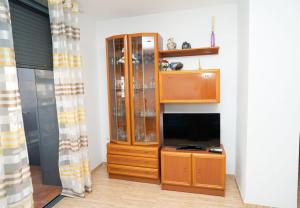 a large wooden cabinet with a tv in a room at Aina in Peniscola