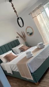 a bedroom with a large bed with a green headboard at Margo Cozy Houses in Mavrovouni