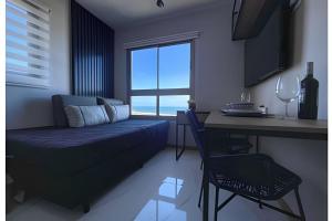 a bedroom with a bed and a table and a desk at New Studios - O paraíso é aqui in Salvador