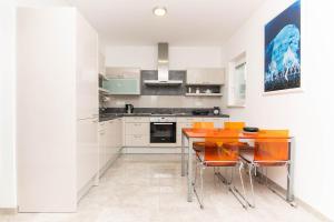 a kitchen with a wooden table and orange chairs at Apartment Nonna Laura in Portorož