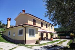 a large yellow house with a tree in front of it at Apartment Nonna Laura in Portorož