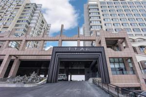 um edifício com um portão em frente a edifícios altos em JI Hotel Yantai Development Zone Housha Plaza em Zhuji