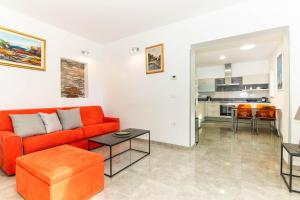 a living room with a orange couch and a table at Apartment Nonna Laura in Portorož +38 photos