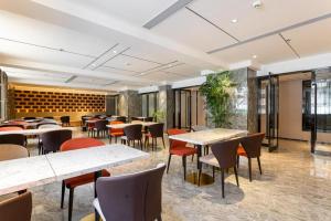 蘭州市にあるStarway Hotel Lanzhou West Passenger Station North Squareのテーブルと椅子が備わるレストラン