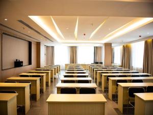 una sala de conferencias con mesas, sillas y una pantalla en Starway Hotel Lanzhou West Passenger Station North Square en Lanzhou