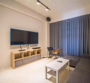 sala de estar con TV de pantalla plana grande en Alley-巷弄75包棟民宿 en Yilan City