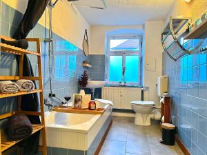 een blauw betegelde badkamer met een wastafel en een toilet bij Bergling Apartment im Zentrum • Netflix • Festungsblick • Obst und Wein • in Königstein an der Elbe