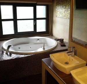 a bathroom with a large tub and a sink at LA ALDEA SOÑADA in Oviedo