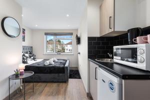 a small apartment with a bed and a kitchen at Charming Serviced Ensuite Modern Studio - Sleeps 2 - Near Wembley Stadium - Good Transport Link to Central London - Harrow HA3 in Hatch End
