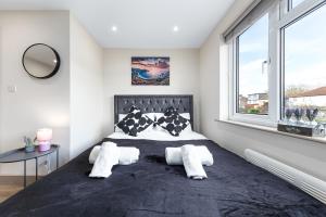 a bedroom with a large bed and a window at Charming Serviced Ensuite Modern Studio - Sleeps 2 - Near Wembley Stadium - Good Transport Link to Central London - Harrow HA3 in Hatch End