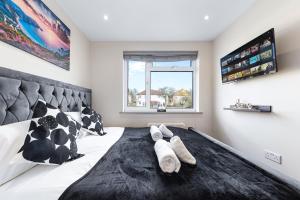 a bedroom with a black and white bed with towels on it at Charming Serviced Ensuite Modern Studio - Sleeps 2 - Near Wembley Stadium - Good Transport Link to Central London - Harrow HA3 in Hatch End