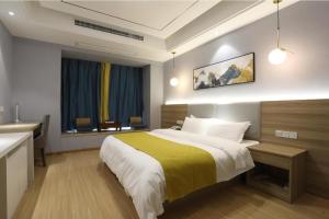 a bedroom with a bed and a desk and a sink at Starway Hotel Nanchang West Lake Wanda Plaza in Taohua