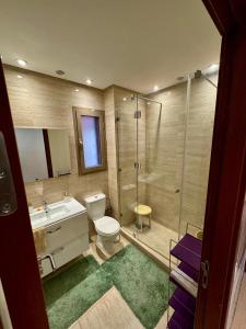 a bathroom with a shower and a toilet and a sink at Golf City Prestigia - Exclusive Apartment in Marrakesh