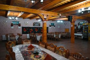 a dining room with tables and chairs in a restaurant at Pensiunea Valea Branzei in Năneşti