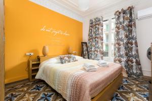 a bedroom with a bed and a yellow wall at Luxury y Elegant Apartment in the centre in Barcelona