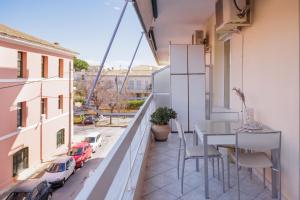balcón con mesa y sillas y vistas a la calle en Zampeli Apartment, en Corfú