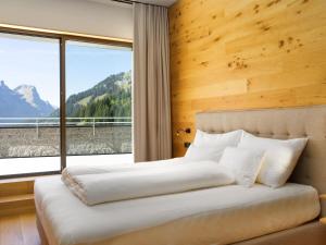 a bedroom with a bed with a large window at top Apartment on the Arlberg with sauna in Schröcken