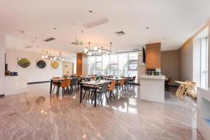a dining room and kitchen with a table and chairs at NIHAO Hotel Linyi Jiefang East Road Financial Building in Linyi