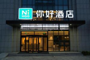 a building with a sign in front of it at NIHAO Hotel Linyi Jiefang East Road Financial Building in Linyi