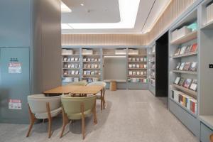 a library with a table and chairs and bookshelves at JI Hotel Zibo Renmin West Road in Zibo