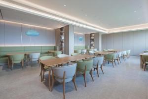 a restaurant with tables and chairs in a room at JI Hotel Zibo Renmin West Road in Zibo