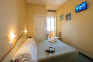 una camera ospedaliera con un letto e una TV a muro di Hotel Crosal a Rimini
