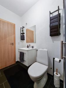 a bathroom with a white toilet and a sink at GOLD Apartman in Sanski most