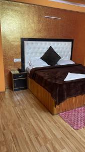 Cette chambre comprend un grand lit et du parquet. dans l'établissement Manali Apple Villa, à Manali