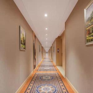 einen langen Flur mit Fliesenboden und einen Flur mit Korridorngthngthngth in der Unterkunft Vienna Hotel Shanxi Datong High-Speed Railway Dongxin International in Shaling