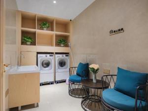 uma lavandaria com um lavatório e uma máquina de lavar roupa em Vienna Hotel Shanxi Datong High-Speed Railway Dongxin International em Shaling