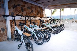 a row of bikes lined up against a stone wall at Kampaoh Cova Negra in Gandía