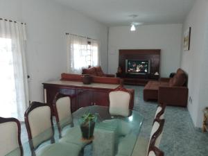 un salon avec une table en verre et un canapé dans l'établissement Casa Itanhaém, à Itanhaém 13 autres photos