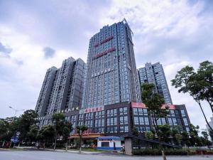 ein hohes Gebäude mit zwei hohen Gebäuden in der Unterkunft Vienna Hotel Yueyang East Station in Yueyang