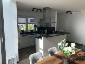ダンガストにあるVilla Wonderful Dangast in the North Sea Parkのテーブルと椅子のあるキッチンとカウンターのあるキッチン