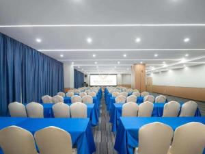 ein Konferenzraum mit blauen Tischen und weißen Stühlen in der Unterkunft Vienna Hotel Lincang New Asia Pacific Times Square in Lincang